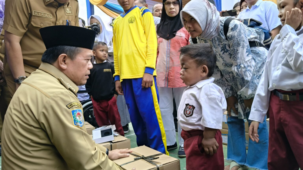 Al Haris Serahkan Bantuan Peralatan dan SPP Program Dumisake Pendidikan di Merangin.